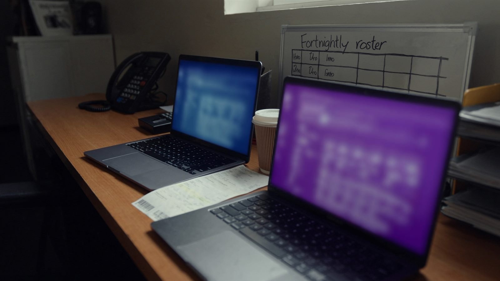 Two laptops on a small Australian office desk showing accounting software